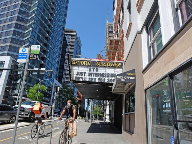Bikers wearing masks in front of Moore Theatre during COVID-19