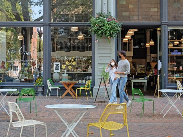 Man and woman wearing face masks, leaving London Plane in Occidental Square, Seattle
