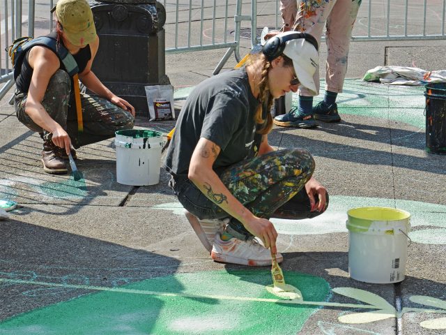 Woman painting sidewalk