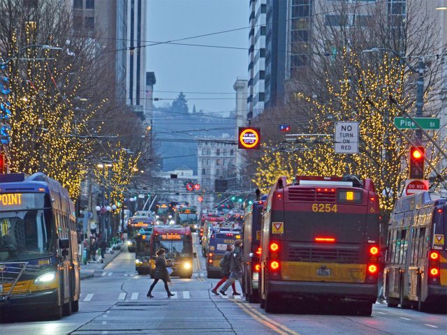 Buses are seen on Third Avenue and Pine Street in downtown Seattle.