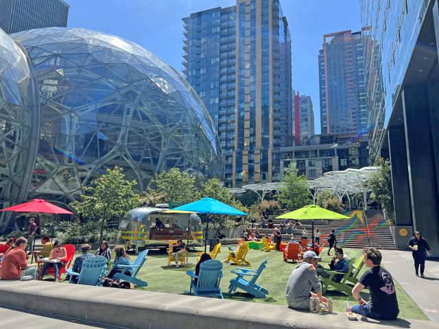Downtown Seattle workers sit and eat lunch on a sunny day outside of the Amazon Spheres.