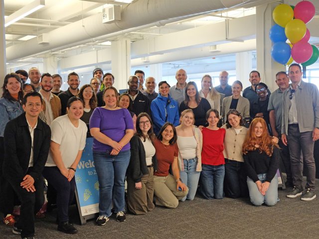 DSA staff smiling in their new office space, with celebratory balloons in the background.